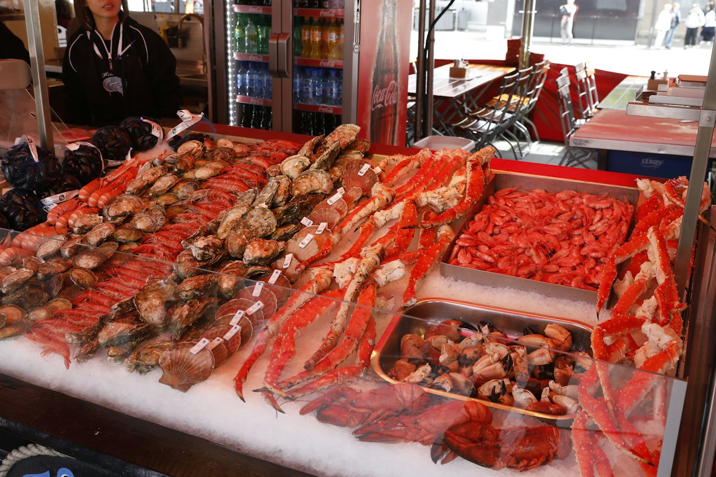 Fresh seafood is displayed on ice at a market counter.
