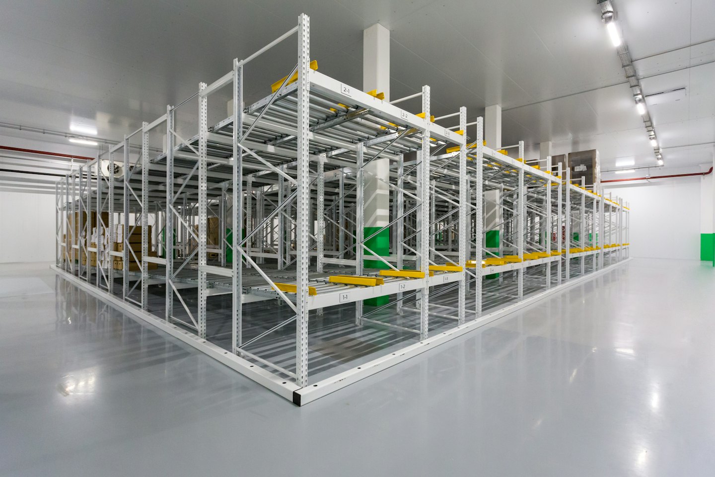 Modern warehouse interior with white pallet racking and yellow accents.